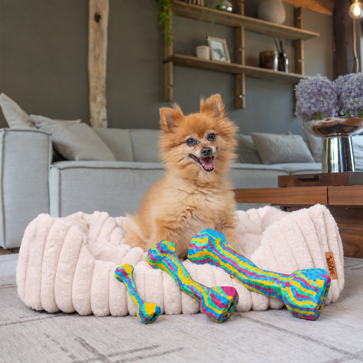 Pale pink | Furry Corduroy Open Front Rectangle Bed: Pomeranian sitting in the Pale pink bed with two toy bones
