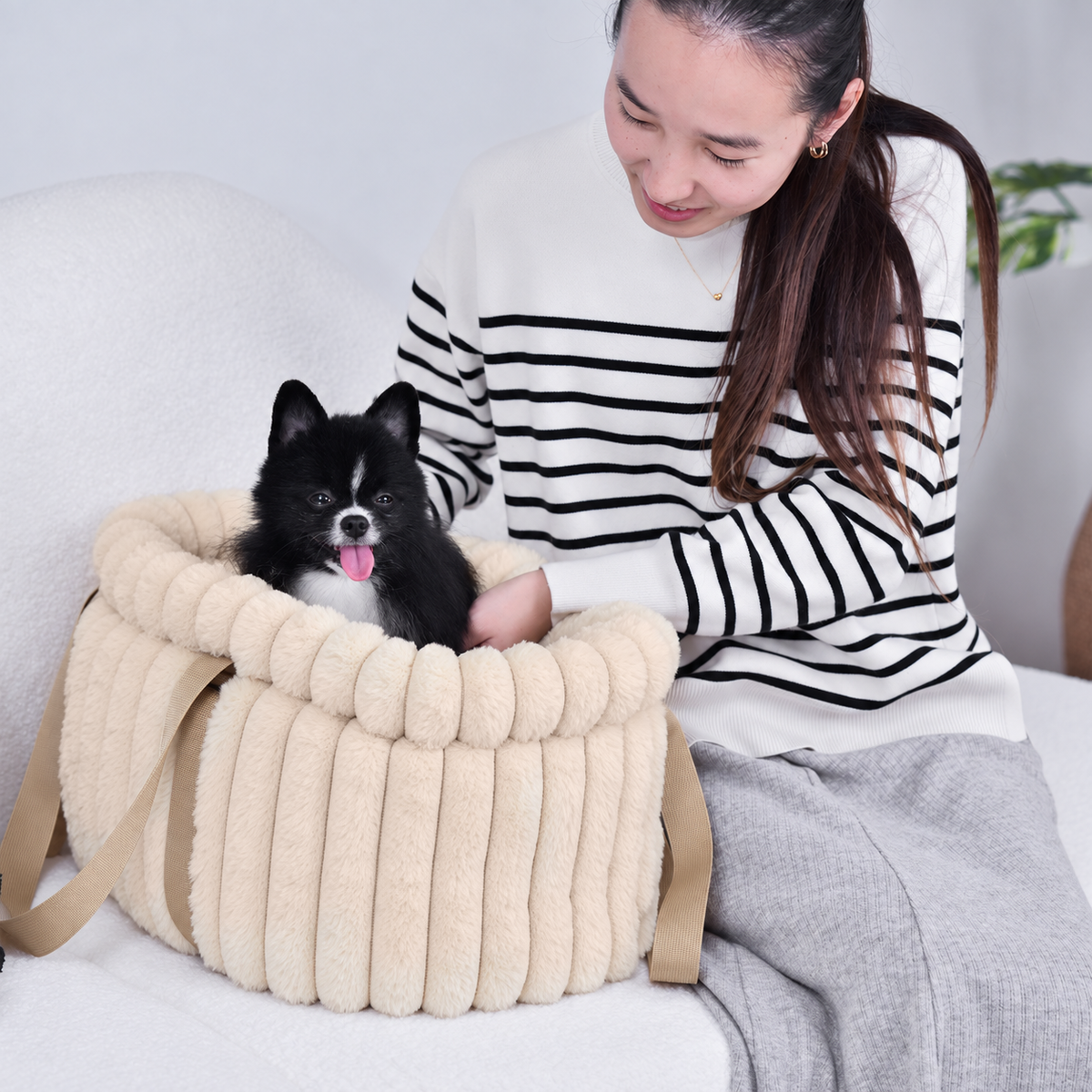 Pale pink | Corduroy Calming Dog Carrier: Woman smiling at a black and white Pomeranian in the Pale pink carrier
