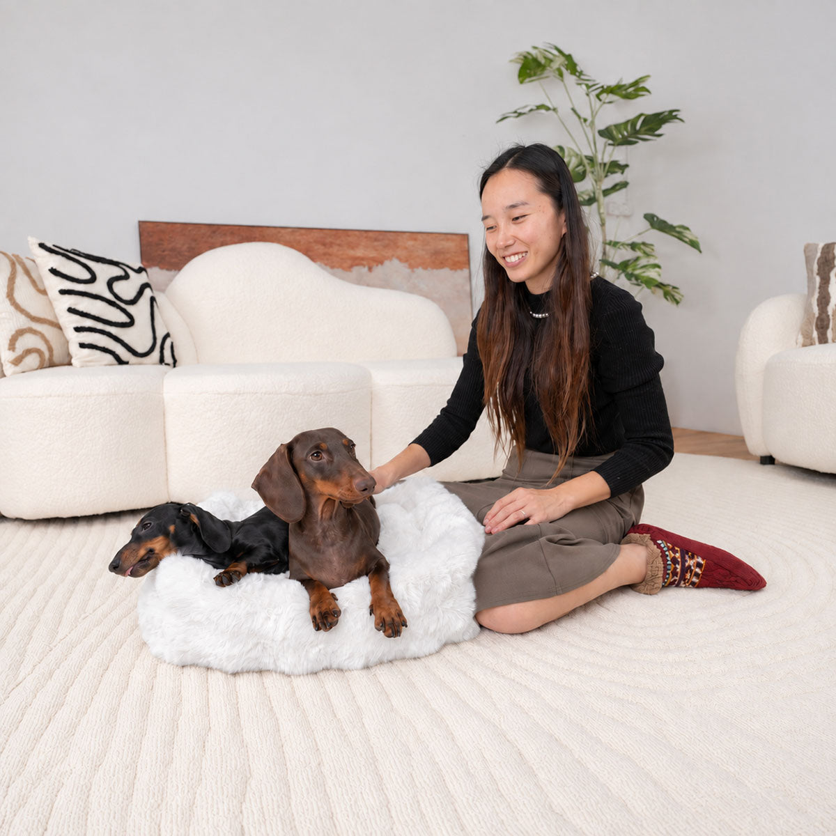 White | Furry Curves Round Bed: A woman on the floor beside two dachshunds in the White round bed
