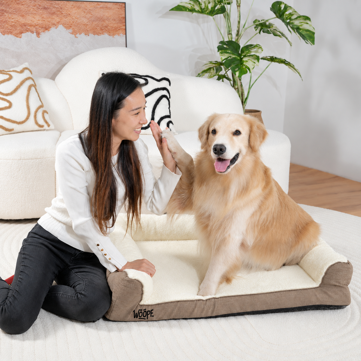 Cream | SNÖR Orthopedic Bed: Woman kneeling beside a golden retriever on the Cream bed in a living room