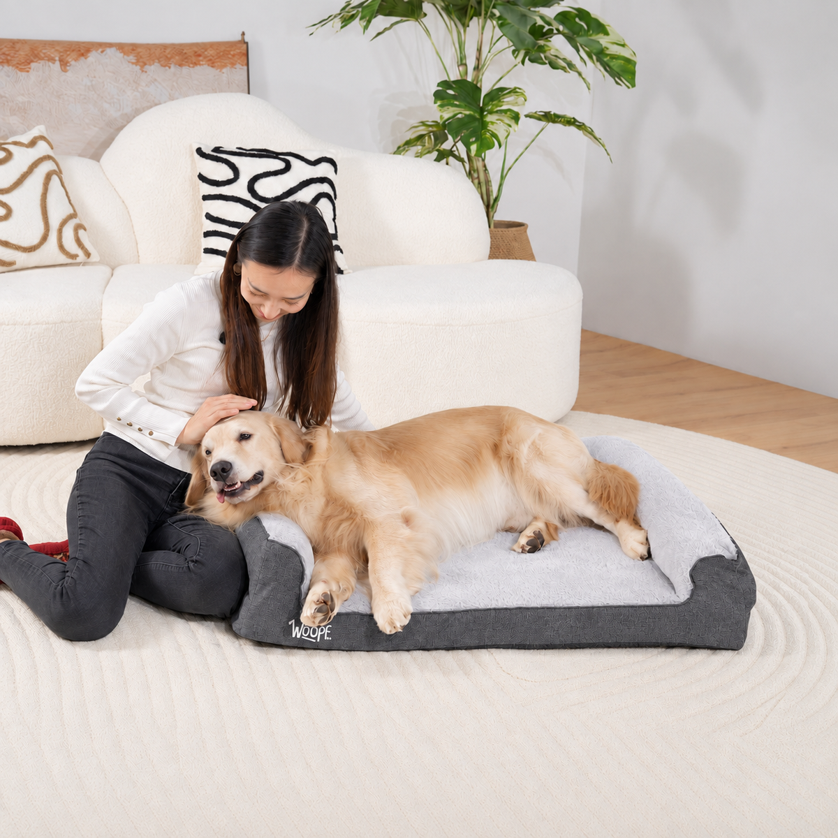 Grey | SNÖR Orthopedic Bed: Woman kneeling beside a golden retriever on the Grey bed in a living room