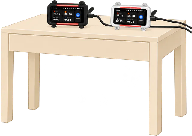 Illustrated black and white trackers charging side by side on a table, each on its own cable